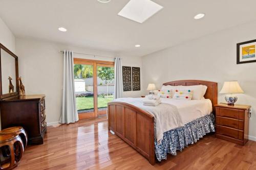 a bedroom with a large bed and a wooden floor at Escondido Villa w Movie Theater Garden GameRoom in Escondido
