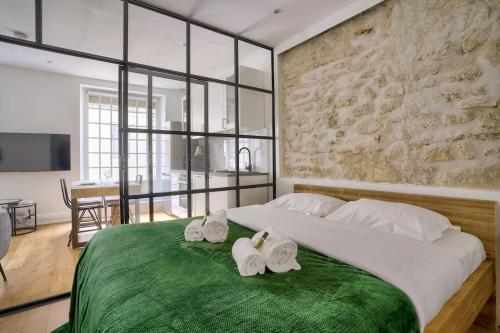 um quarto com uma cama grande e toalhas em Magnifique appartement proche Tour Eiffel em Paris