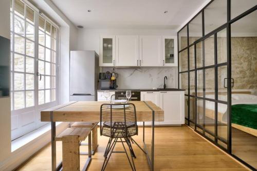 - une cuisine avec une table, des chaises et un lit dans l'établissement Magnifique appartement proche Tour Eiffel, à Paris