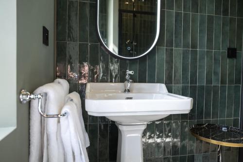 a bathroom with a sink and a mirror and towels at Maison Heronnière in Compiègne