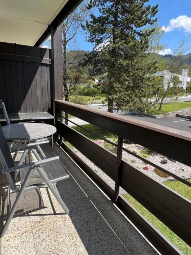 a deck with a chair and a table and a tree at Appartementhaus Birkenwald in Seefeld in Tirol