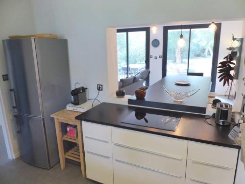 eine Küche mit einem Kühlschrank und einer Arbeitsplatte in der Unterkunft Villa ONGUI ETHORRI Villa pour 6 ou 8 personnes Wifi gratuit in Soorts-Hossegor