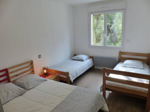 Zimmer mit 2 Betten und einem Fenster in der Unterkunft Villa ONGUI ETHORRI Villa pour 6 ou 8 personnes Wifi gratuit in Soorts-Hossegor