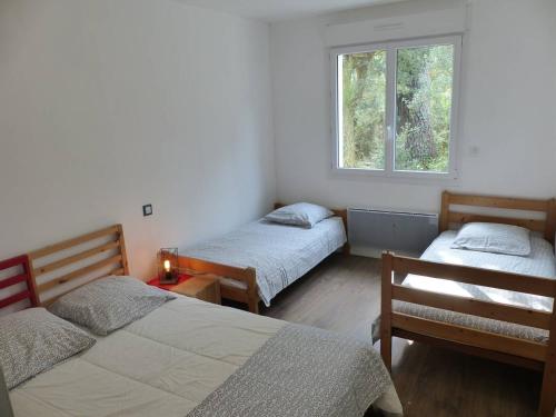 une chambre avec deux lits et une fenêtre dans l'établissement Villa ONGUI ETHORRI Villa pour 6 ou 8 personnes Wifi gratuit, à Hossegor