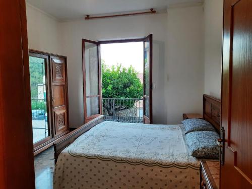 ein Schlafzimmer mit einem Bett und einem großen Fenster in der Unterkunft Appartamento Giustenice in Giustenice