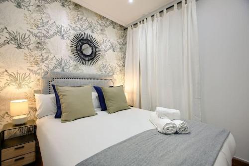 a bedroom with a large white bed and a mirror at Cozy flat in the center of Madrid-COMEND-3-DE in Madrid