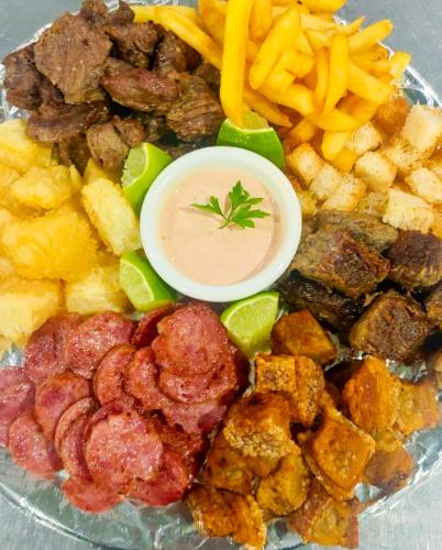 a plate of food with sausage and french fries at Motel Caribe in Belo Horizonte