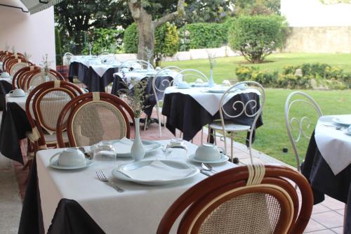 a row of tables and chairs with plates and utensils at GRANDE HOTEL PARIS by STAY HOTELS in Porto