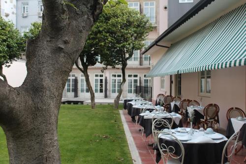 une rangée de tables et de chaises devant un bâtiment dans l'établissement GRANDE HOTEL PARIS by STAY HOTELS, à Porto
