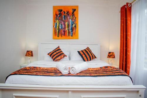 a bedroom with a bed with two towels on it at Classy African - themed 1 BR apartment in Karen in Karen