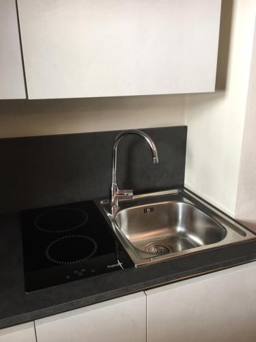 a kitchen sink with a faucet and a stove at Vicolo San Giuseppe 8A e 8B in Alba
