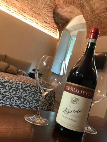 a bottle of wine and a glass on a table at Vicolo San Giuseppe 8A e 8B in Alba