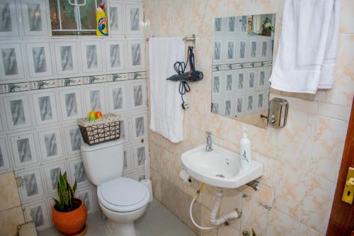a bathroom with a toilet and a sink at Classy African - themed 1 BR apartment in Karen in Karen