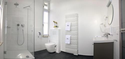a bathroom with a shower and a toilet and a sink at Gasthof Ziegler Hotel & Restaurant in Lindau