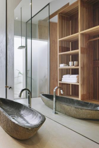 two sinks in a bathroom with glass walls at KA BRU 1100 Boutique Hotel in Taipu