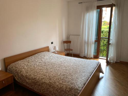 a bedroom with a bed and a sliding glass door at LaMonica.House in Salò