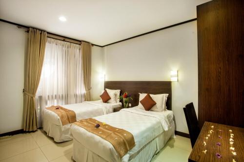 A bed or beds in a room at Summer Hills Hotel & Villas Bandung