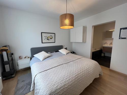 a bedroom with a large bed and a bathroom at Large Luxury Business Apartment Geel in Geel