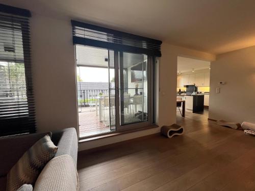 a living room with a couch and a large window at Business Accommodation Luxury XL Geel in Geel