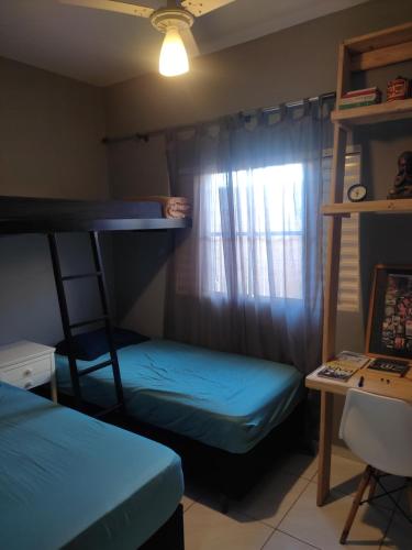 a room with two bunk beds and a desk at Gray house 1 - Londrina JD. Santiago in Londrina
