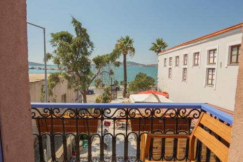 a balcony with a view of the ocean and buildings at Deniz Önü Guesthouse in Ayvalık