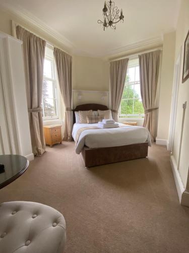 a large bedroom with a bed and windows at Lubnaig Guest House in Callander