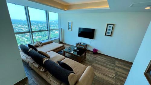 a living room with a couch and a flat screen tv at Centaurus Two Bedroom Apartment in Islamabad