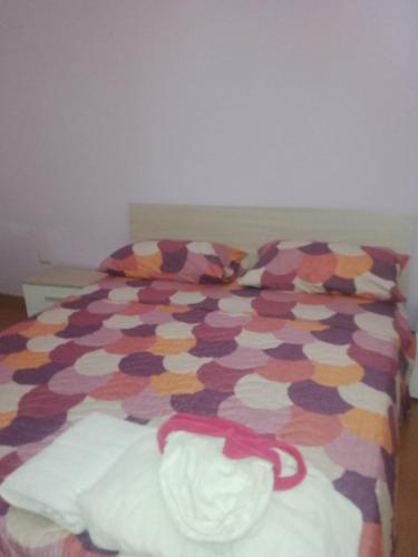 Una cama con un edredón multicolor. en Il glicine, en Laureana Cilento