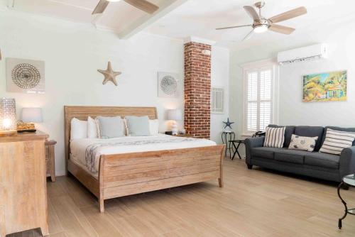 a bedroom with a bed and a couch at Southernmost Point Guest House & Garden Bar in Key West