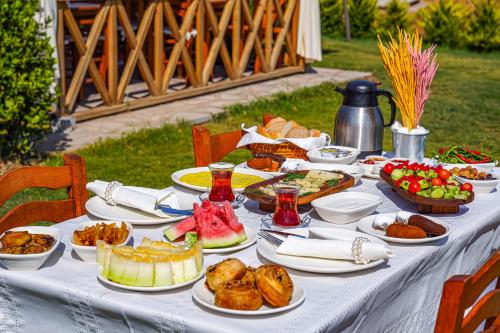una mesa blanca con comida encima en Bakbay Otel Bozcaada en Çanakkale