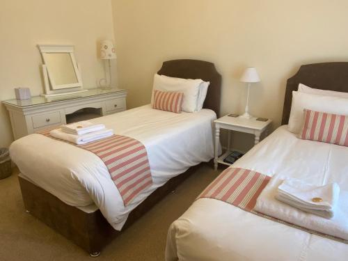 a hotel room with two beds and a mirror at Lubnaig Guest House in Callander