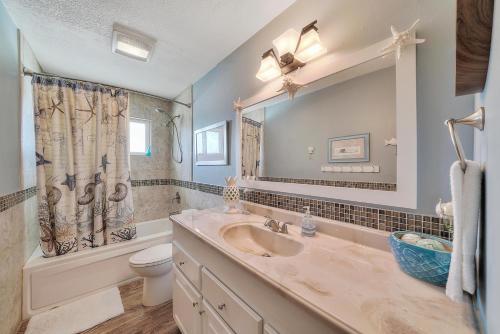 a bathroom with a sink and a toilet and a mirror at Beach Dream in Navarre