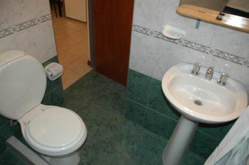 y baño con aseo y lavamanos. en PARQUE APART HOTEL en San Juan