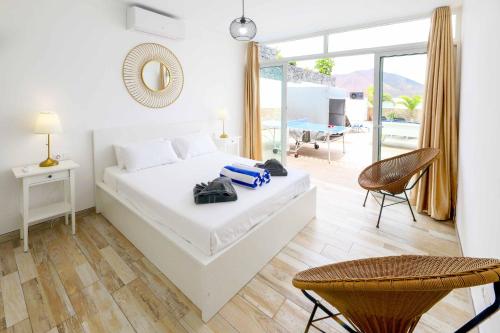 een witte slaapkamer met een bed en een balkon bij Villa Bella in Playa Blanca