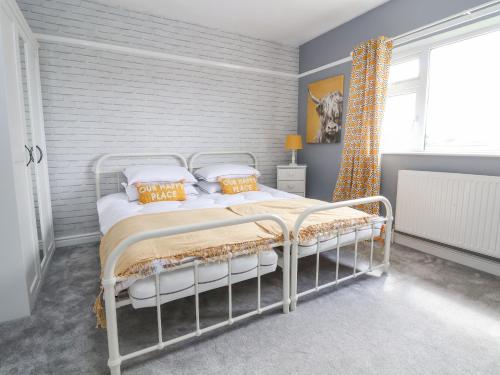 um quarto com uma cama com almofadas brancas e laranjas em Shire Cottage em Shrewsbury
