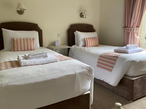 um quarto com 2 camas e toalhas em Lubnaig Guest House em Callander