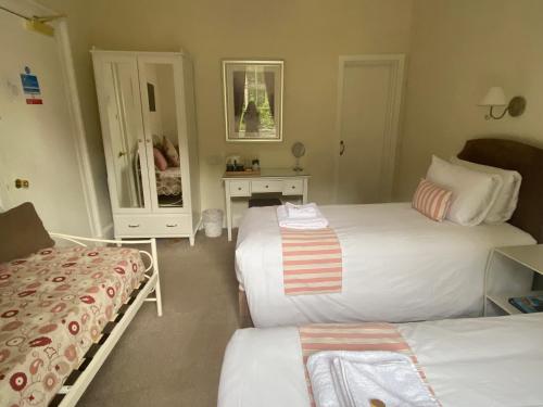 a small bedroom with two beds and a mirror at Lubnaig Guest House in Callander