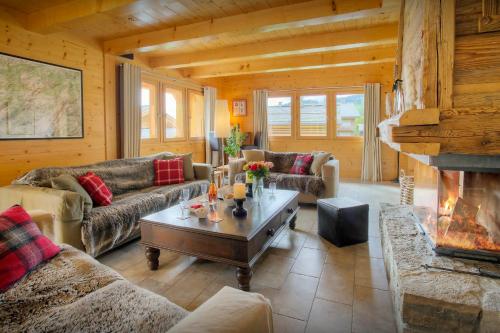 ein Wohnzimmer mit Sofas und einem Kamin in der Unterkunft Chalet Tolar - OVO Network in Le Grand-Bornand