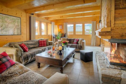 un salon avec des canapés et une cheminée dans l'établissement Chalet Tolar - OVO Network, au Grand-Bornand