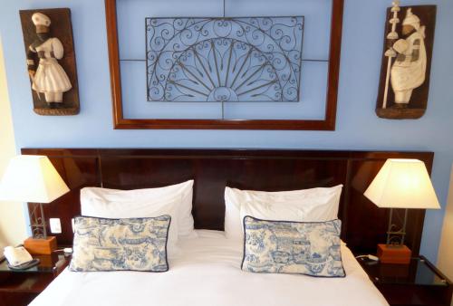 a bedroom with a bed with two lamps and two pillows at Hotel Casa do Amarelindo in Salvador