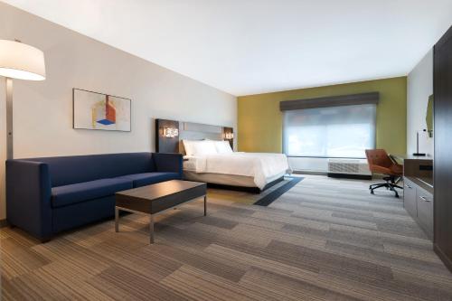 a hotel room with a couch and a bed at Holiday Inn Express & Suites - Glendale Downtown in Glendale