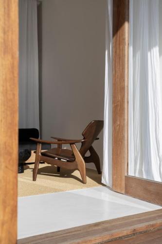 a wooden chair and a table in a room at KA BRU 1100 Boutique Hotel in Taipu