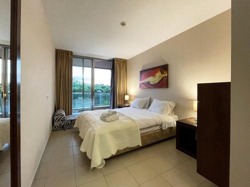 um quarto com uma cama grande e uma janela grande em Herdade dos Salgados, T3-11B2A, Vila das Lagoas, Albufeira em Galé