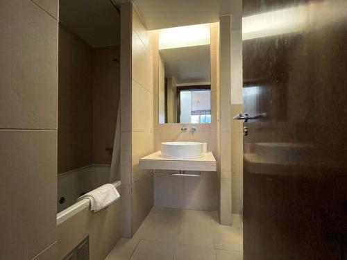 uma casa de banho com um lavatório, um espelho e uma banheira em Herdade dos Salgados, T3-11B2A, Vila das Lagoas, Albufeira em Galé