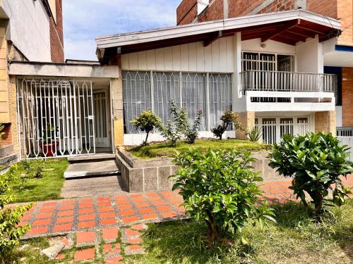 uma casa com um passadiço de tijolos em frente em Sereni Laureles Hotel Cafe em Medellín