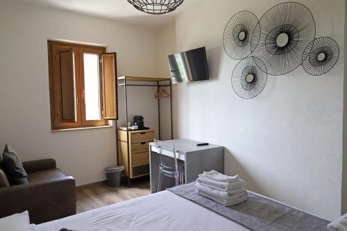 a bedroom with a bed and a couch and fan at B&B Casa Madeo in San Demetrio Corone