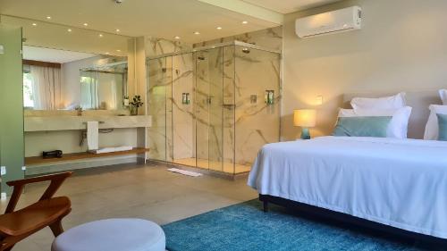 a bedroom with a large bed and a shower at île de Pipa - Ma Plage Hotel in Pipa