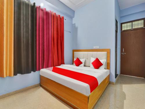 a bedroom with a large bed with red curtains at Flagship Hotel Aradhya Galaxy in Bhauli