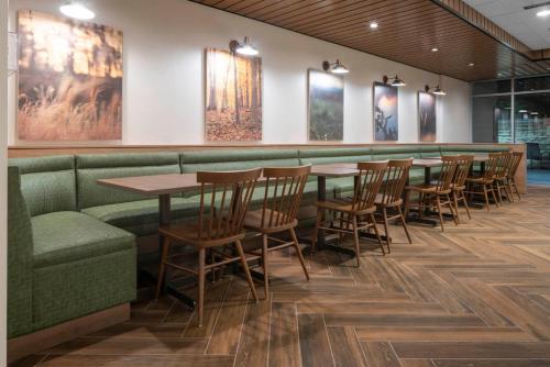 Fairfield by Marriott Inn & Suites Dallas DFW Airport North, Irving في ايرفينغ: مطعم على الحائط طاولات وكراسي ولوحات