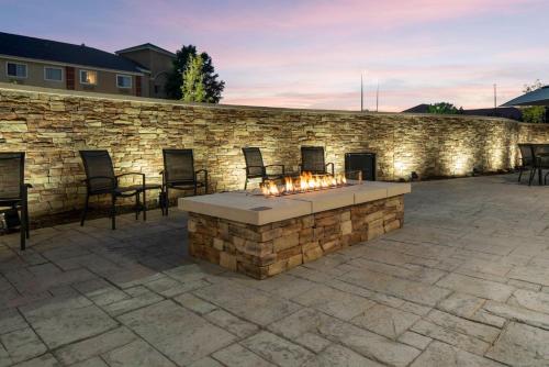 a stone patio with a fire pit in front of a stone wall at Fairfield by Marriott Inn & Suites Dallas DFW Airport North, Irving in Irving
